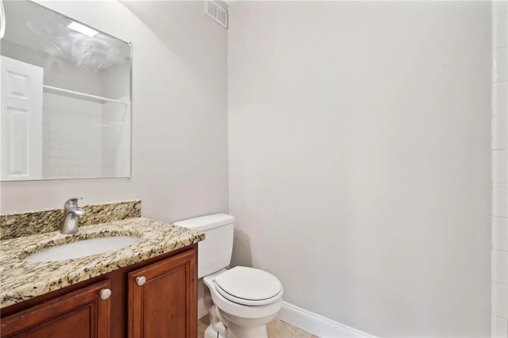 Bathroom featuring toilet, vanity, and bathtub/shower combo