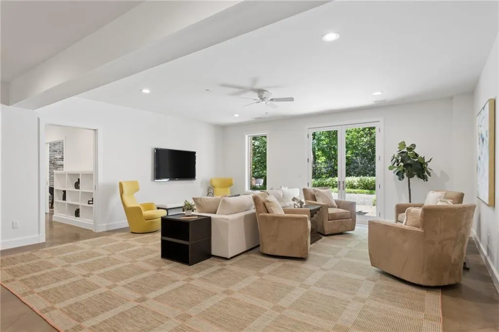 Recessed ceiling lighting, a ceiling fan, wood-finish flooring, built-in shelving, and French doors to the exterior