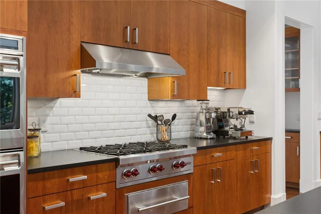Wood-finish cabinetry paired with a stainless steel range hood and appliances