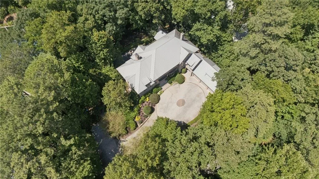 Spacious property featuring a circular drive, mature trees, and a multi-level roofline