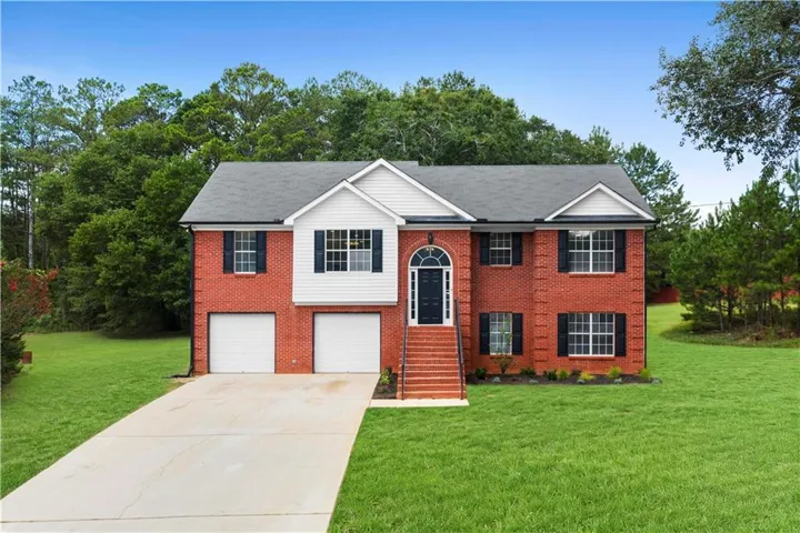 Brick exterior with white siding accents and a dark shingle roof
