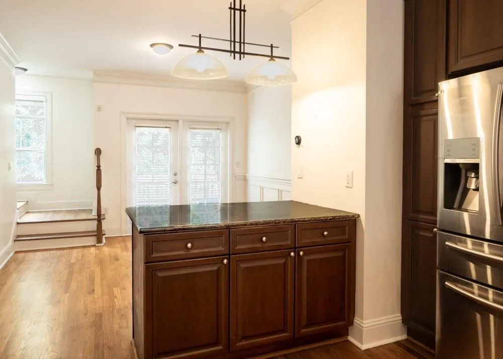 Kitchen with stainless steel refrigerator with ice dispenser, french doors, a peninsula, light wood-type flooring, and crown molding