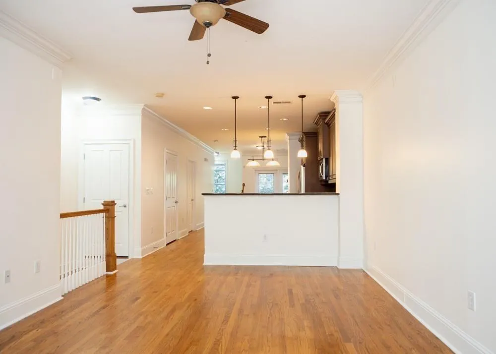 Unfurnished living room featuring a ceiling fan, l