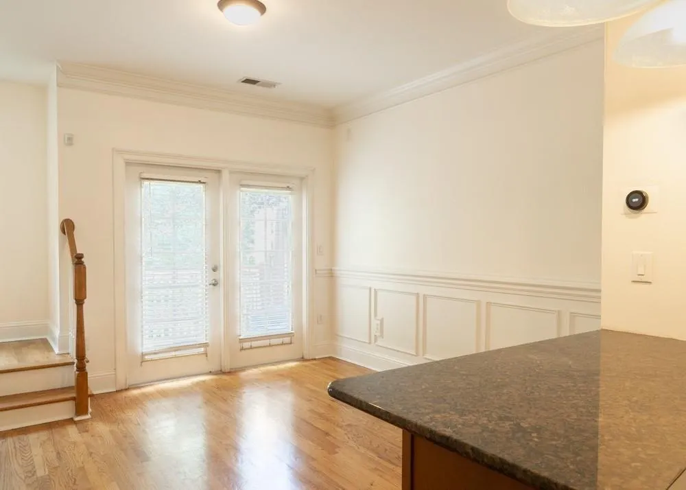 Entryway featuring light wood-style flooring, french doors, and ornamental molding