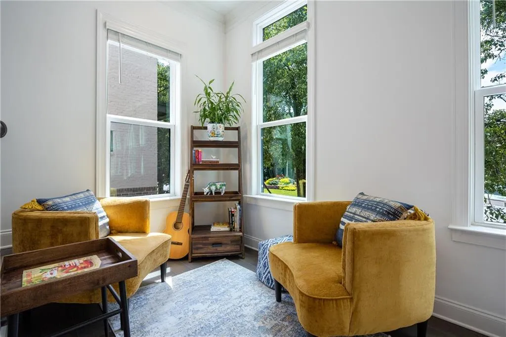 Living area featuring healthy amount of natural light, wood finished floors, and ornamental molding