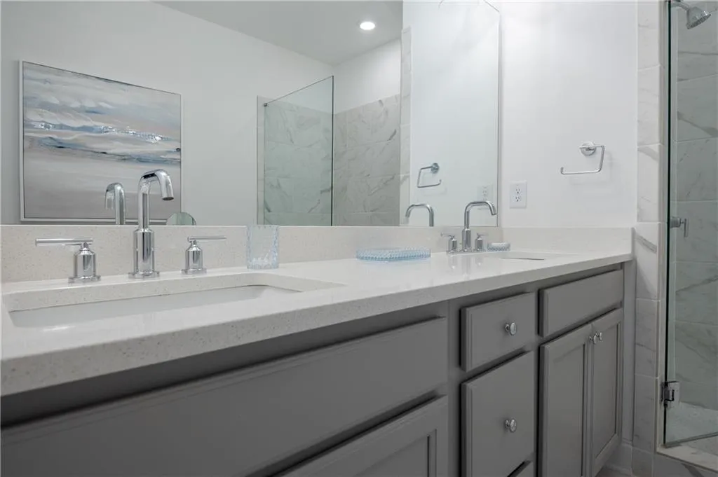 Bathroom with double vanity and a stall shower