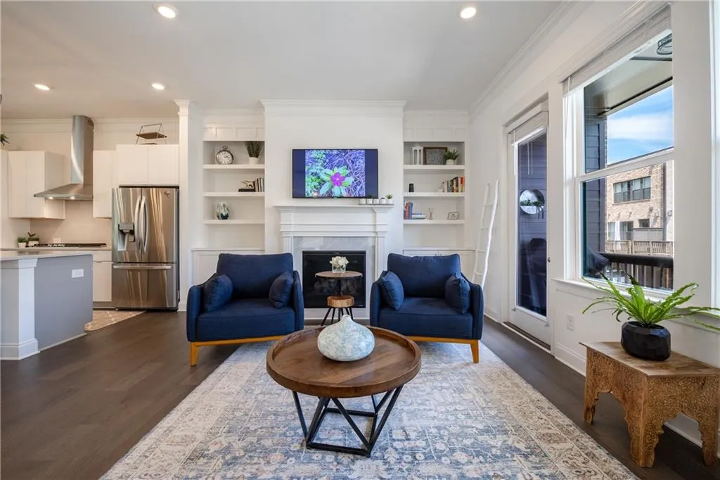 Living area with recessed lighting, dark wood finished floors, crown molding, and a high end fireplace