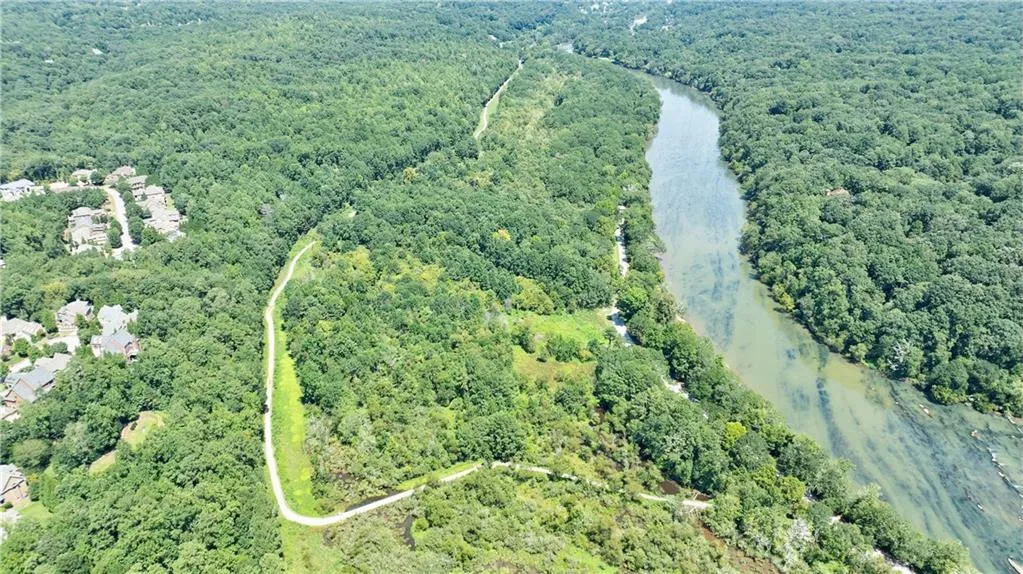 Aerial overview of property's location with a forest and a large body of water