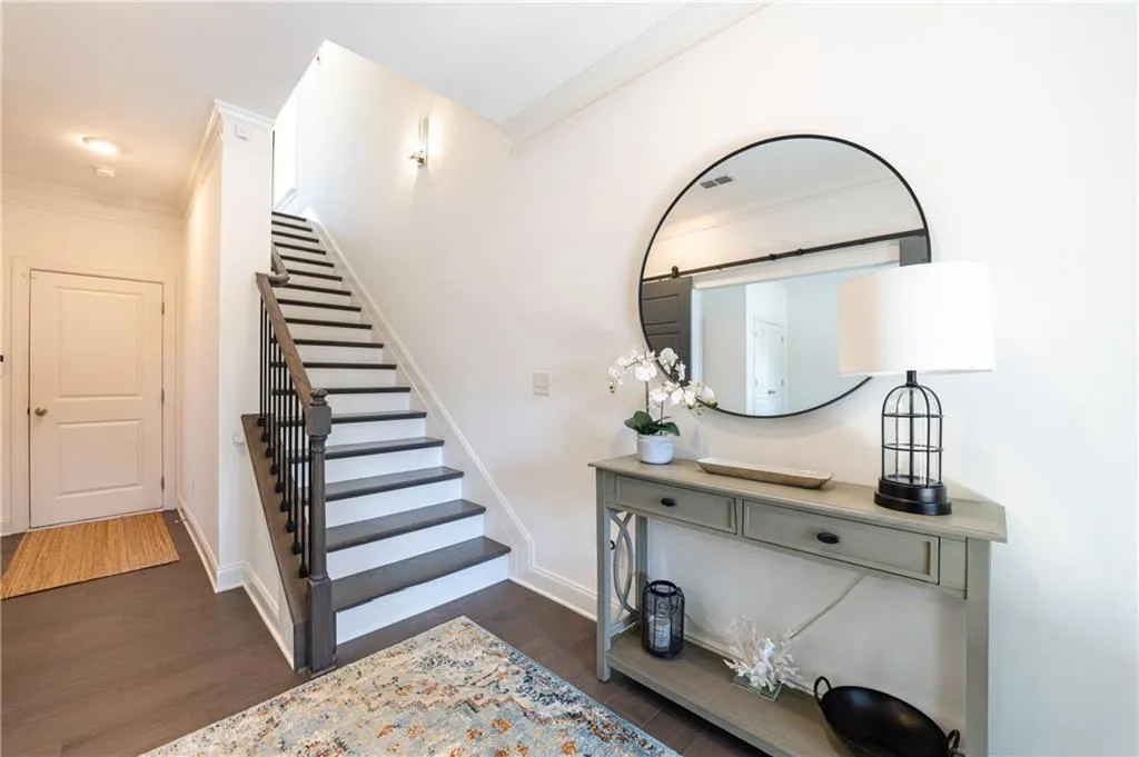 Stairway with crown molding and wood finished floors