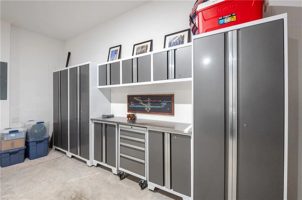 Detailed view of concrete flooring, electric panel, and freestanding refrigerator