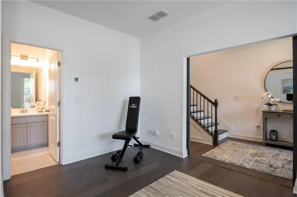 Workout room with dark wood-style flooring and baseboards