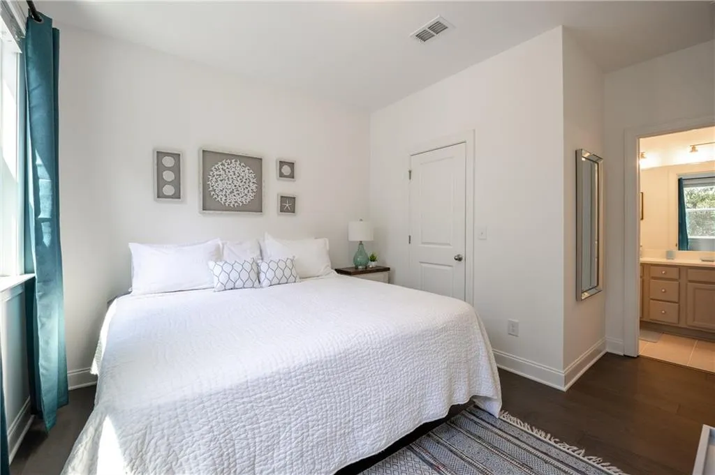 Bedroom featuring dark wood finished floors and ensuite bath