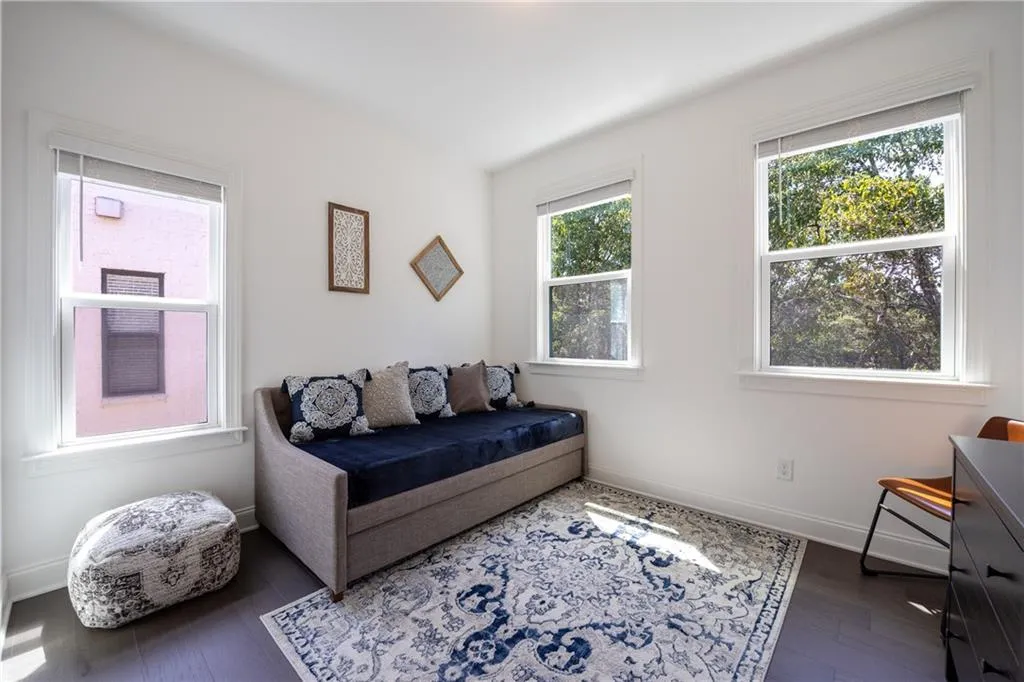 Sitting room featuring dark wood-style floors and baseboards