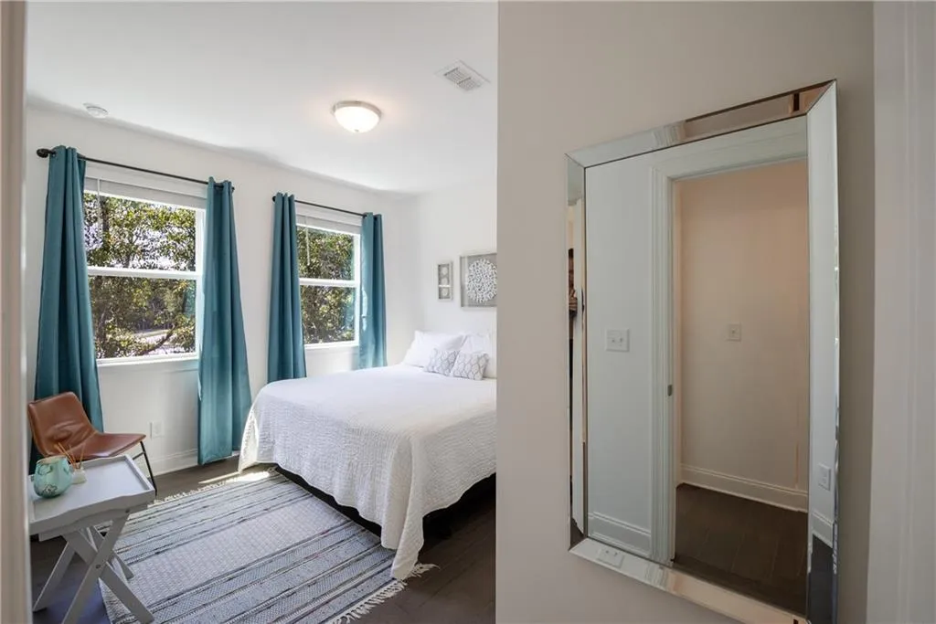 Bedroom with dark wood finished floors and baseboards