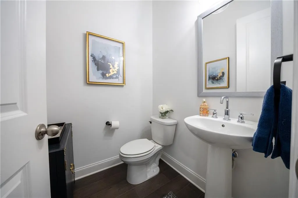 Bathroom featuring baseboards and dark wood-style flooring