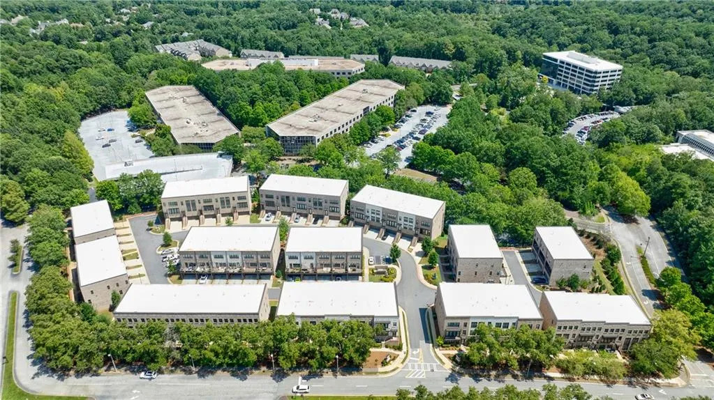 Bird's eye view of apartment complex and a heavily wooded area