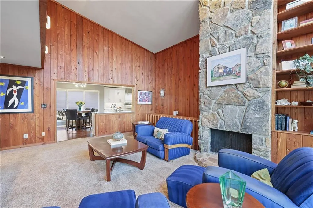 Vaulted den displaying 2 story stone fireplace - view toward