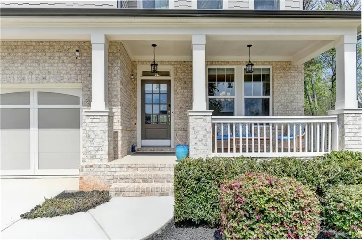 Doorway to property with a porch and brick siding
