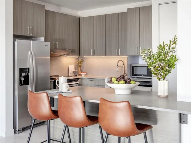 Kitchen featuring a breakfast bar area, stainless steel appliances, kitchen peninsula, and decorative backsplash