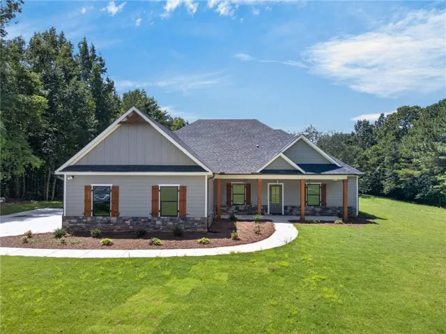 Contemporary home featuring a stone and siding exterior, a covered front porch with wood columns, and a concrete walkway
