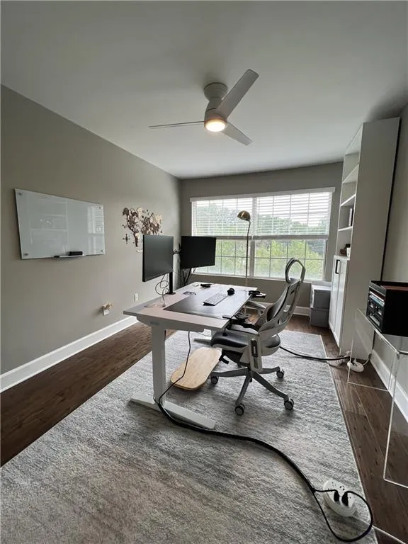 Office space featuring dark hardwood / wood-style flooring and ceiling fan