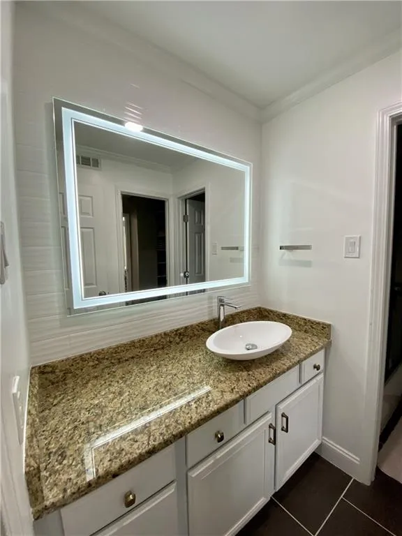 Bathroom featuring vanity, tile floors, and ornamental molding