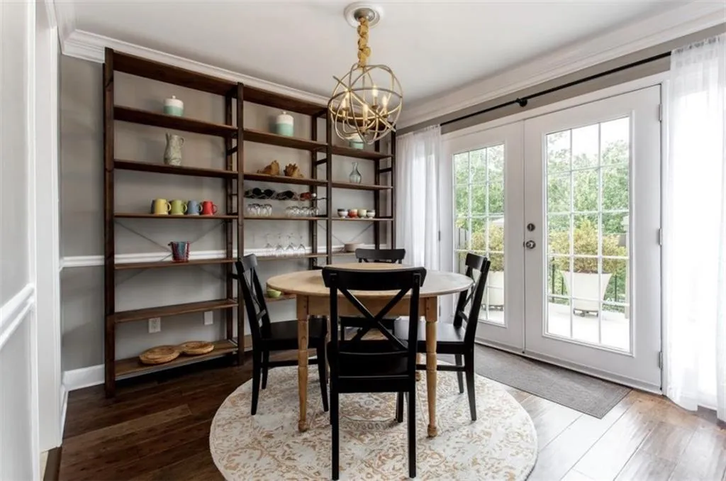 Dining space with ornamental molding, wood-type flooring, french doors, and a notable chandelier