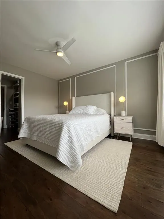 Bedroom with ceiling fan and dark hardwood / wood-style floors