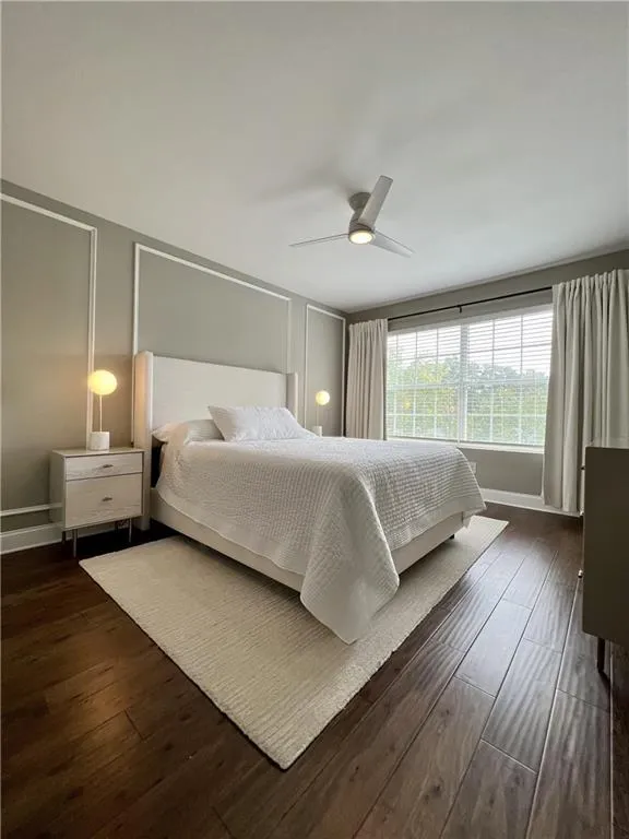 Bedroom with ceiling fan and dark hardwood / wood-style flooring