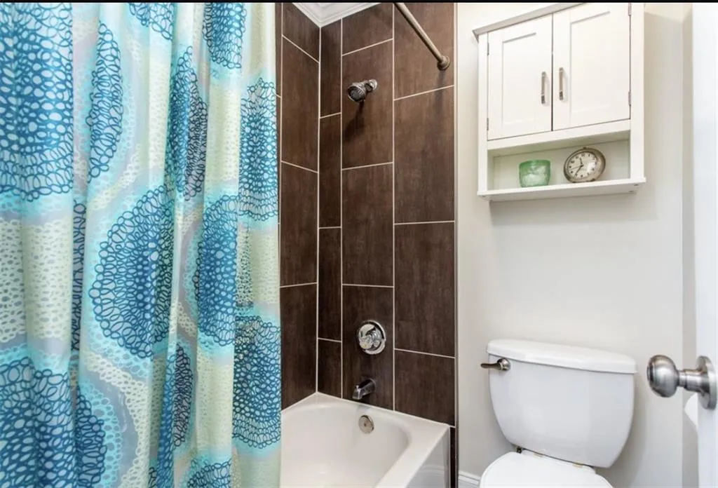 Bathroom with shower / tub combo with curtain and toilet