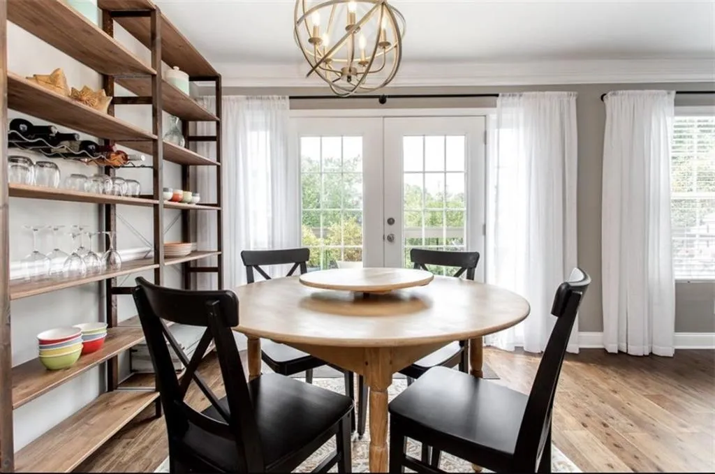 Dining room with french doors, plenty of natural light, crown molding, and light wood-type flooring