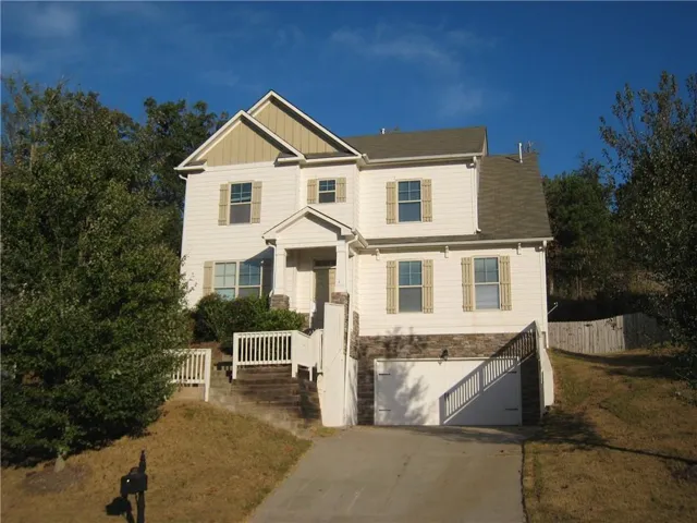 Two-story residence with white siding and a prominent two-car garage