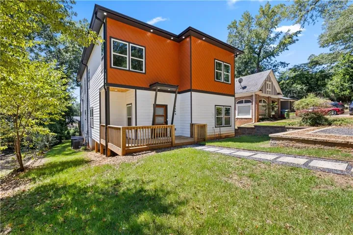 Rear view of property with a yard and a wooden deck
