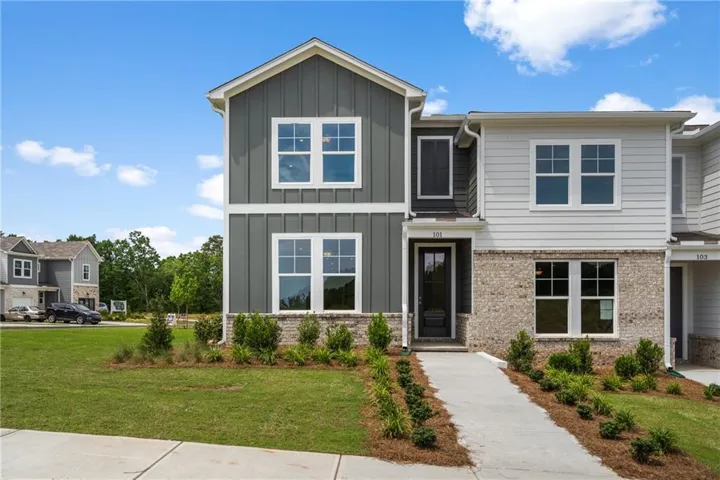 Craftsman inspired home with board and batten siding, a front lawn, and brick siding
