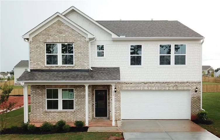 Two-story residential exterior featuring a light-colored brick facade, white siding, a covered front porch, a dark front entry door, and an attached two-car garage