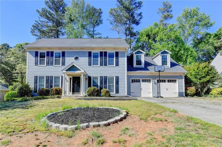 Two-story residence featuring light blue siding, a covered entry, and dark window shutters