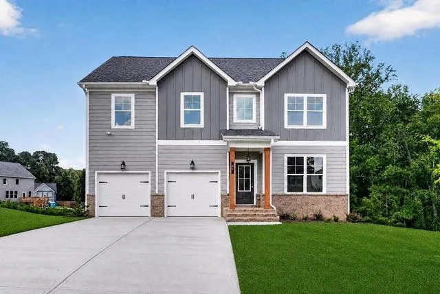 Two-story exterior with mixed siding, stone accents, a two-car garage, and a covered entry