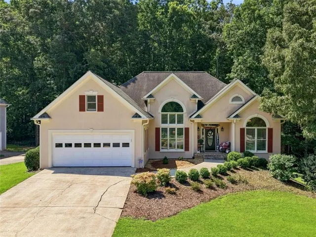 Stucco exterior with gabled roof lines, arched windows, and decorative red shutters
