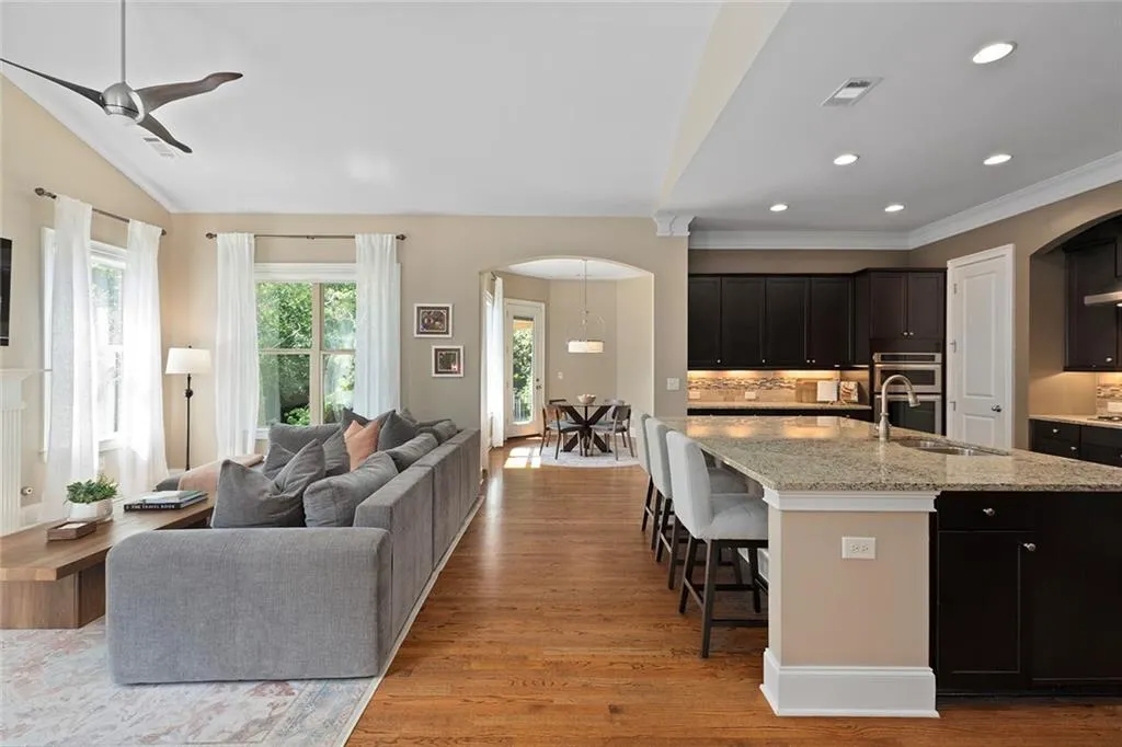 Living room featuring ornamental molding, built in features, and hardwood / wood-style floors Living room featuring ornamental molding, built in features, and hardwood / wood-style floors