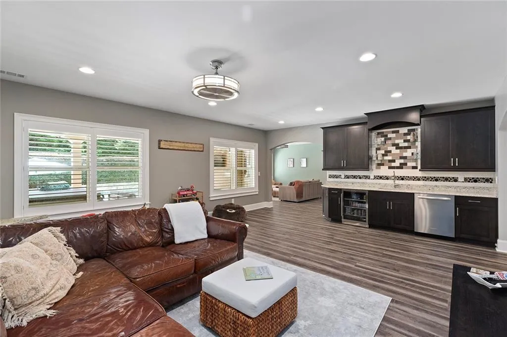 Living room featuring dark wood-type flooring, wine cooler, and sink Living room featuring dark wood-type flooring, wine cooler, and sink