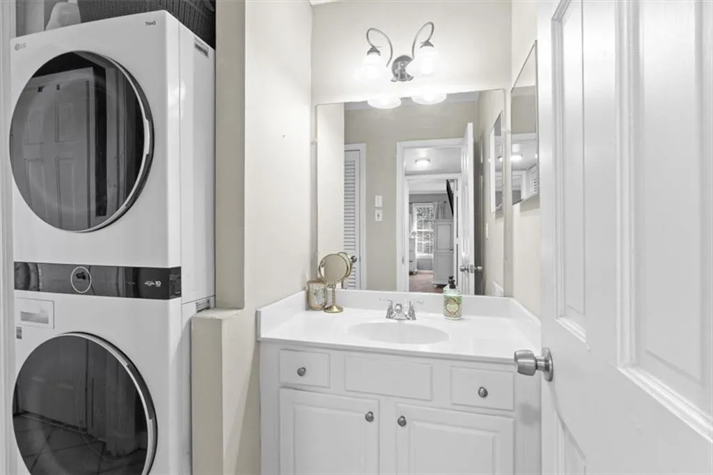 Bathroom with vanity and stacked washer / drying machine