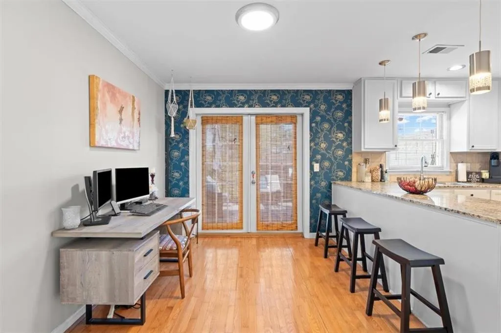 Office featuring light wood-style floors, crown molding, and french doors