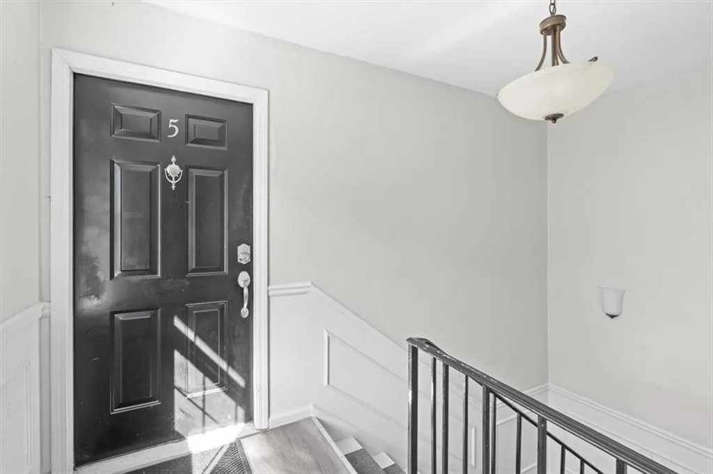 Foyer with a decorative wall, wainscoting, and light wood-type flooring