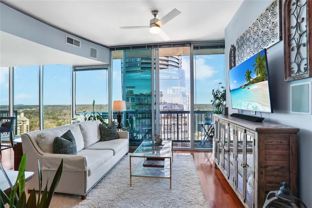 Hall featuring floor to ceiling windows, a chandelier, dark wood-style floors, and baseboards