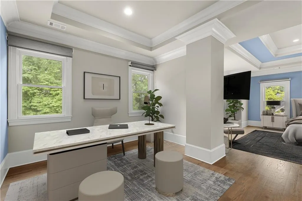 Office area with a healthy amount of sunlight, dark hardwood / wood-style flooring, and a raised ceiling