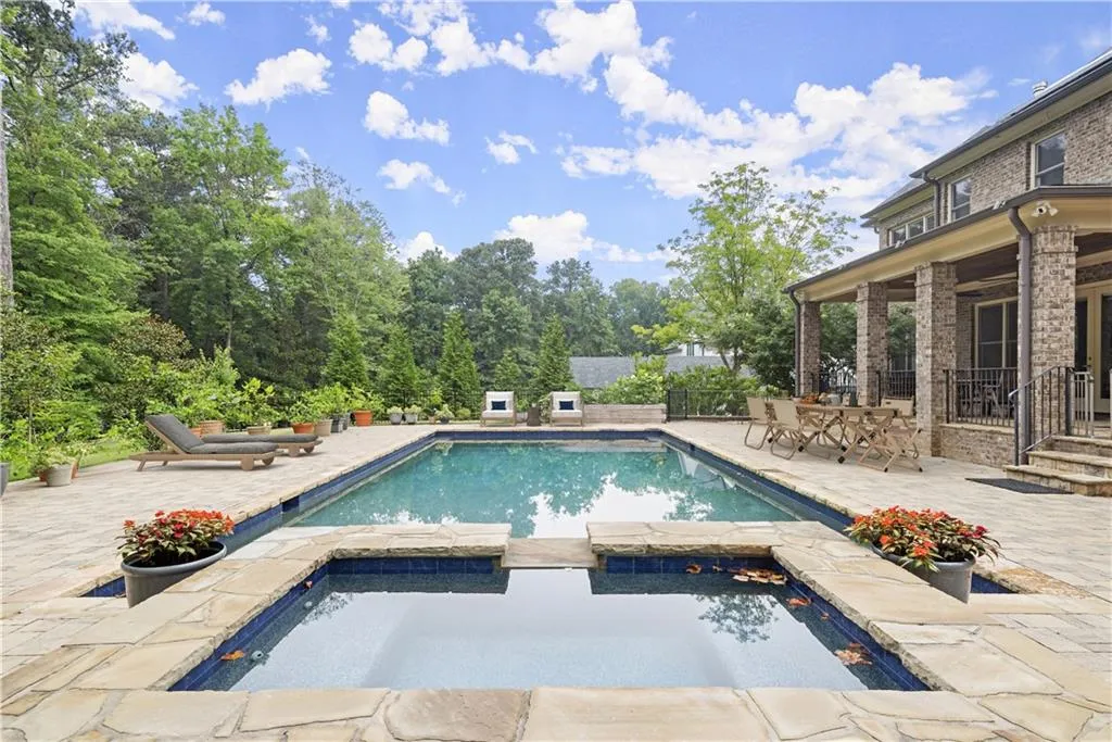 View of pool with an in ground hot tub and a patio