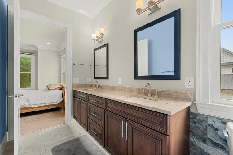 Bathroom featuring double sink vanity, ornamental molding, and tile floors