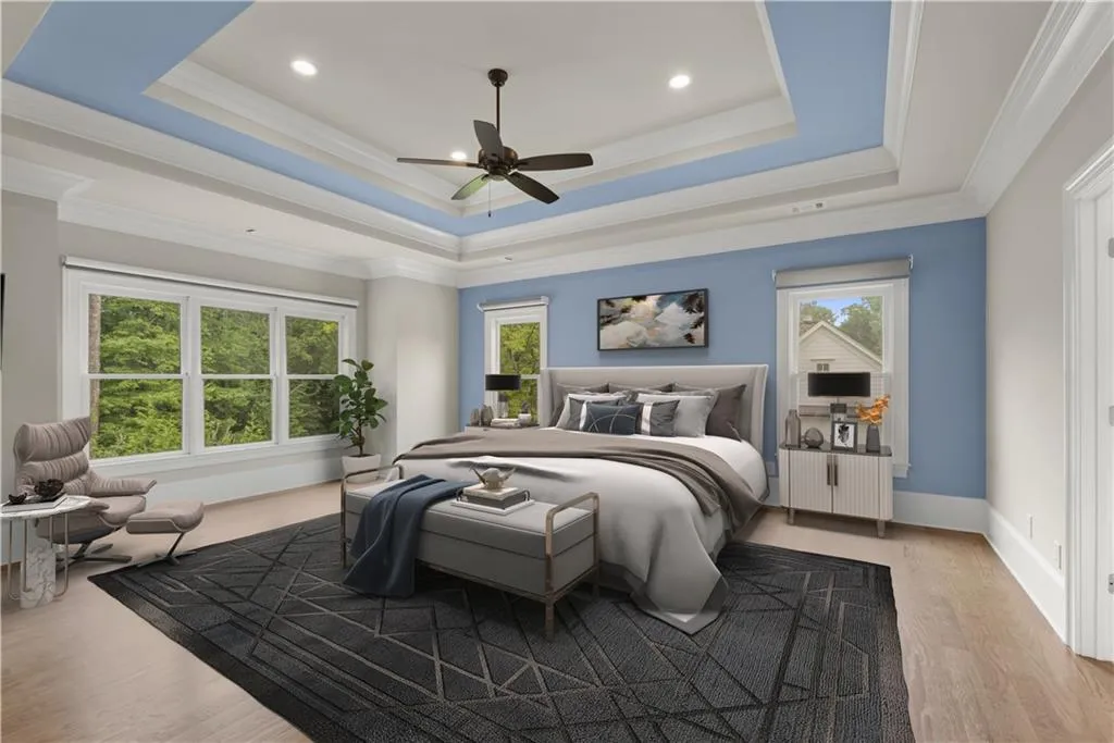 Bedroom with a raised ceiling, crown molding, ceiling fan, and light hardwood / wood-style floors