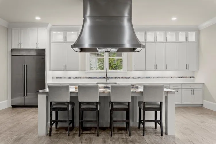 Kitchen featuring island exhaust hood, stainless steel built in fridge, light wood-type flooring, and white cabinetry