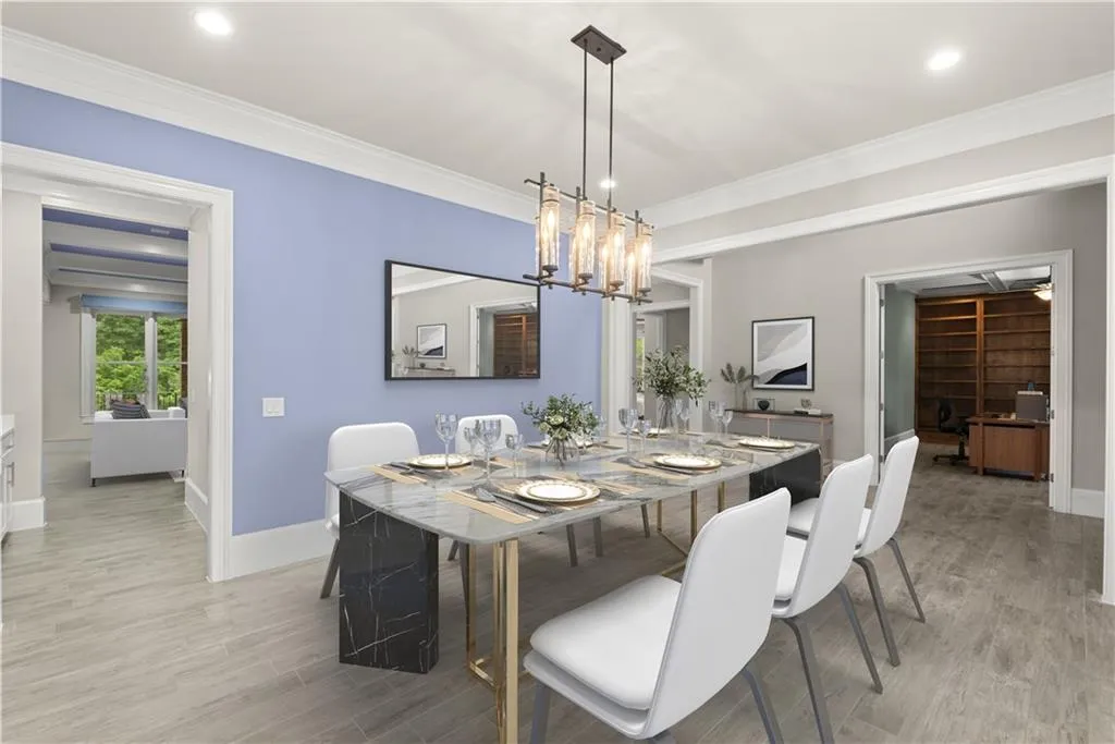 Dining space with light hardwood / wood-style flooring, ornamental molding, and an inviting chandelier